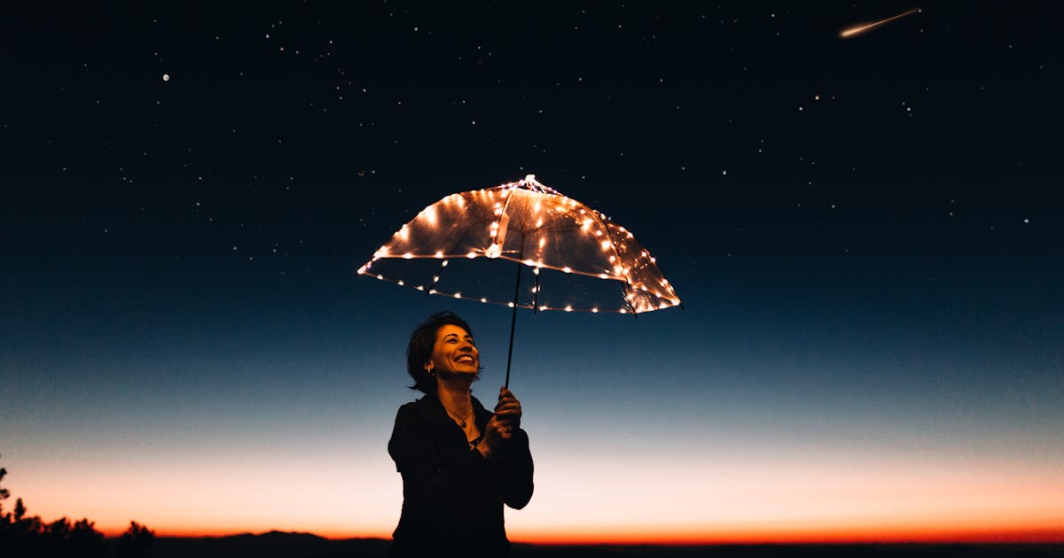 a person holding an umbrella, realizing that they need umbrella insurance