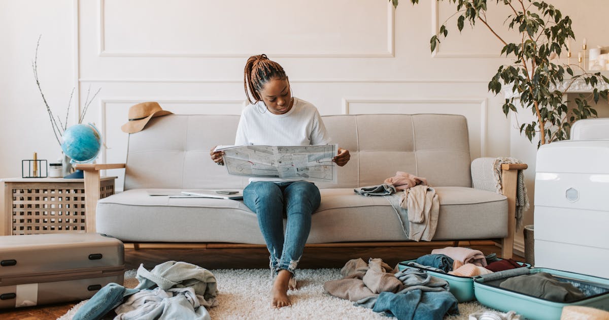 A woamn thinking about her home's security while she travels for the holidays. Photo by Vlada Karpovich httpswww.pexels.comphotowoman-in-white-long-sleeve-sitting-on-a-sofa-7368166